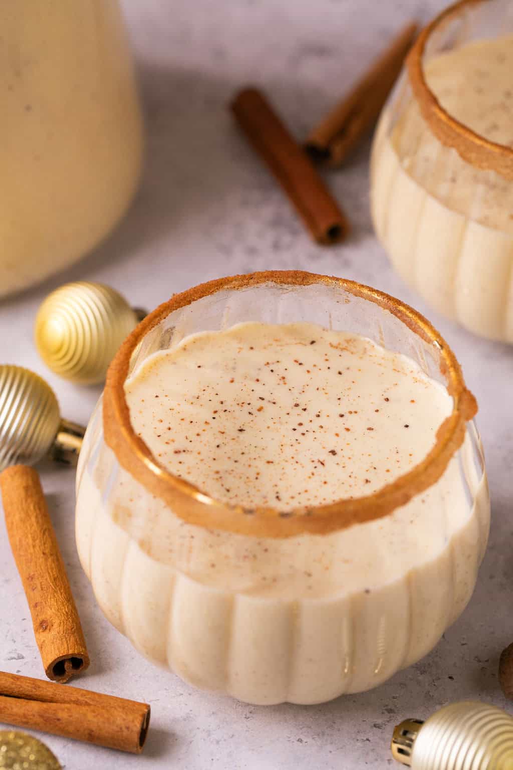 dairy free eggnog in a wine glass with a cinnamon sugar rim.