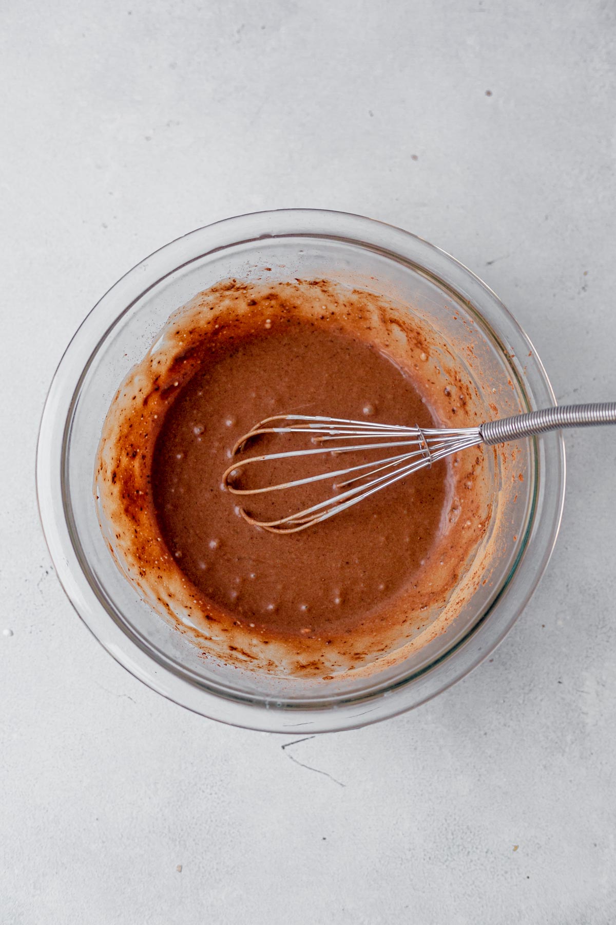 chocolate custard for bread pudding in a glass bowl with a whisk