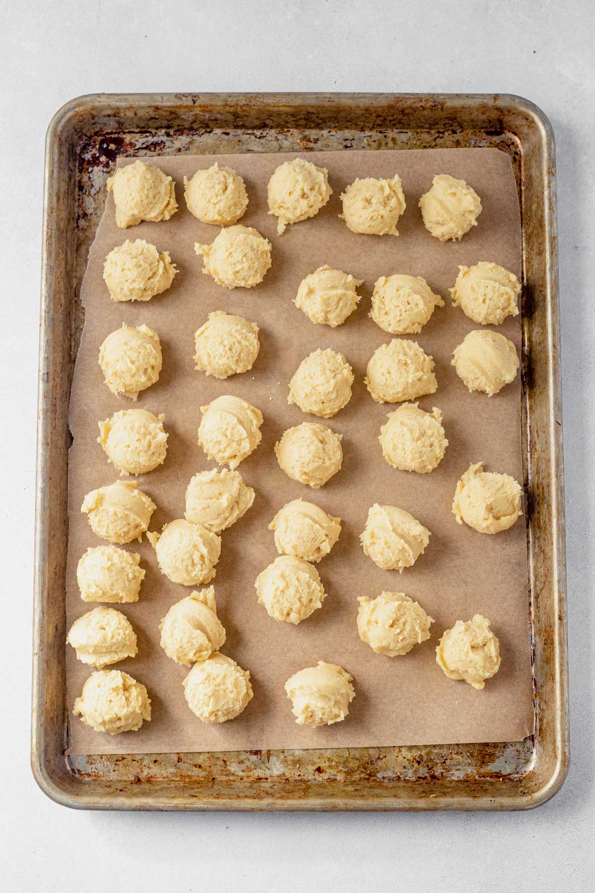 italian wedding cookie dough scooped out onto a large baking sheet