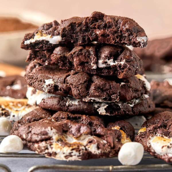 Mexican hot chocolate cookies broken in half and stacked on a wire rack.