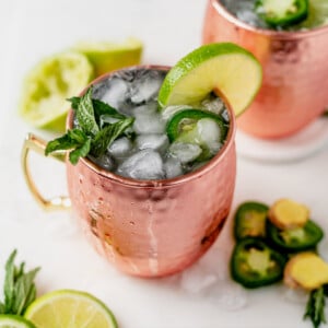 moscow mule with tequila in a copper mug topped with mint and a lime wedge