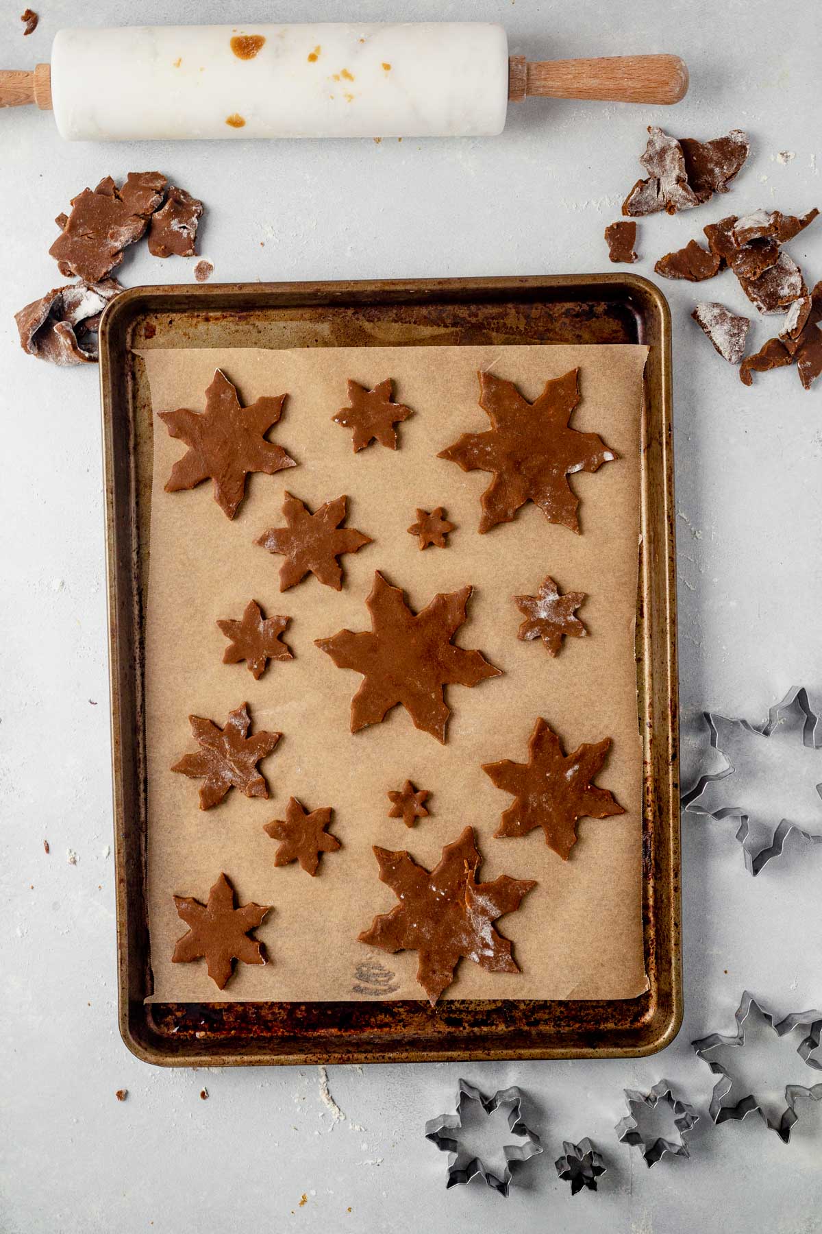 snowflake cookies on a parchment lined baking sheet