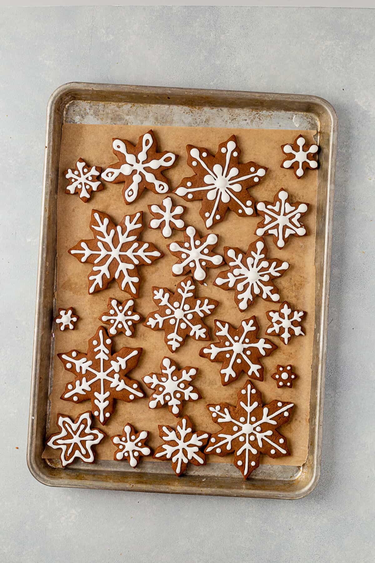 iced snowflake cookies on a cookie sheet
