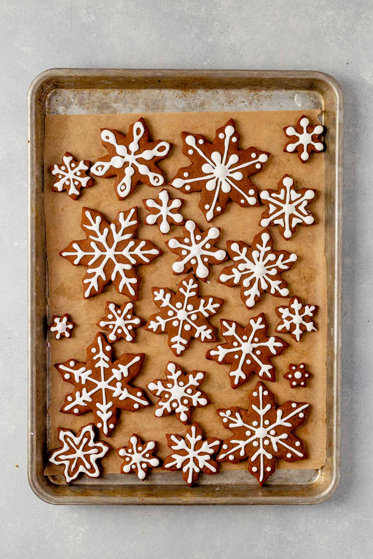 snowflake cookies with royal icing on a baking sheet