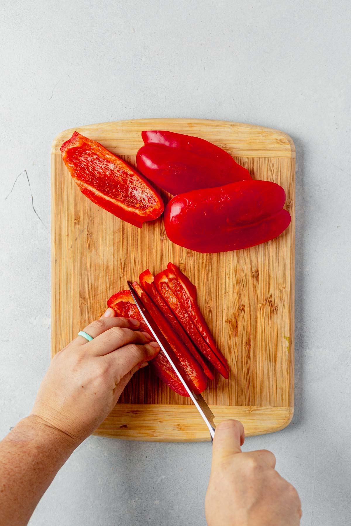 red bell pepper sliced on a wooden cutting board
