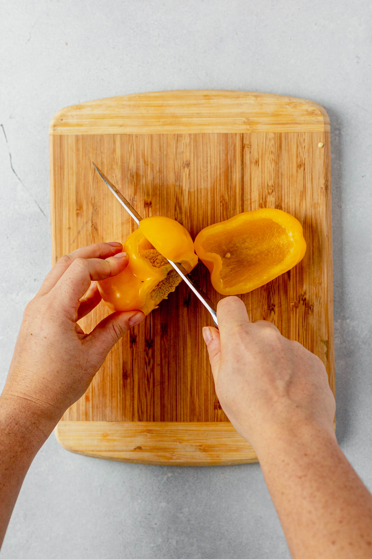 cutting around the seeds of a yellow bell pepper