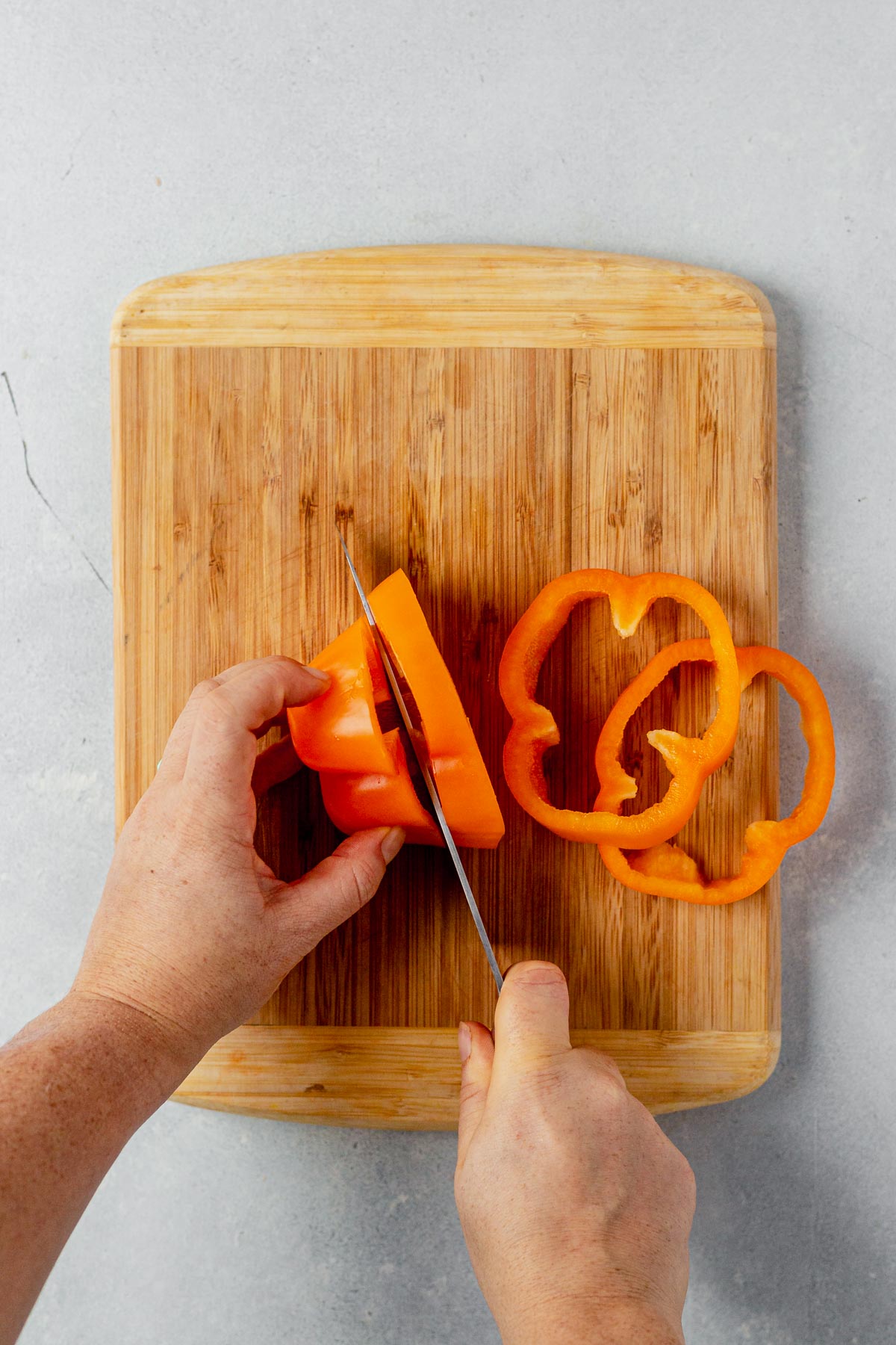 cutting an orange bell pepper into rings