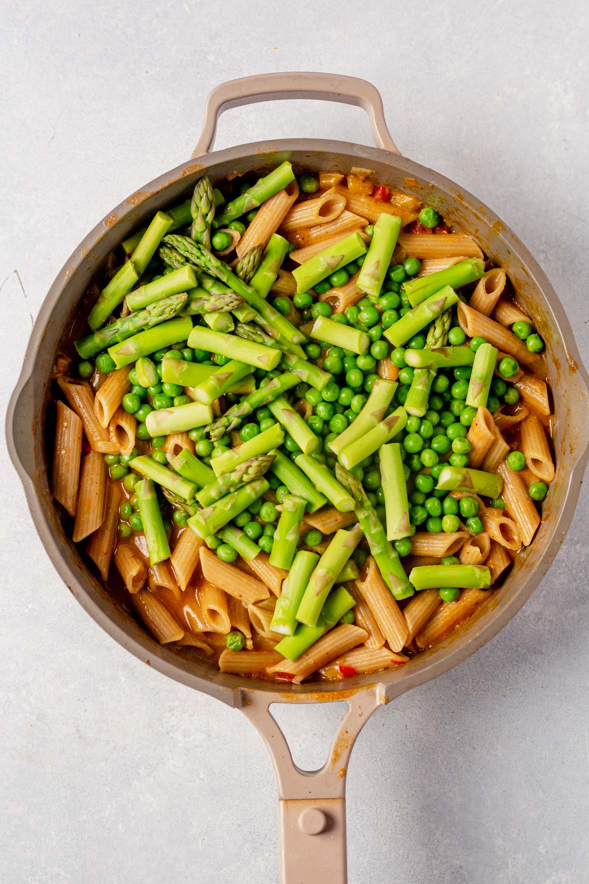 asparagus and peas on top of spicy chicken chipotle pasta