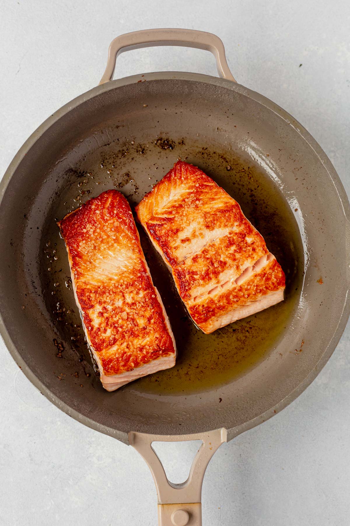 seared salmon filets in a skillet