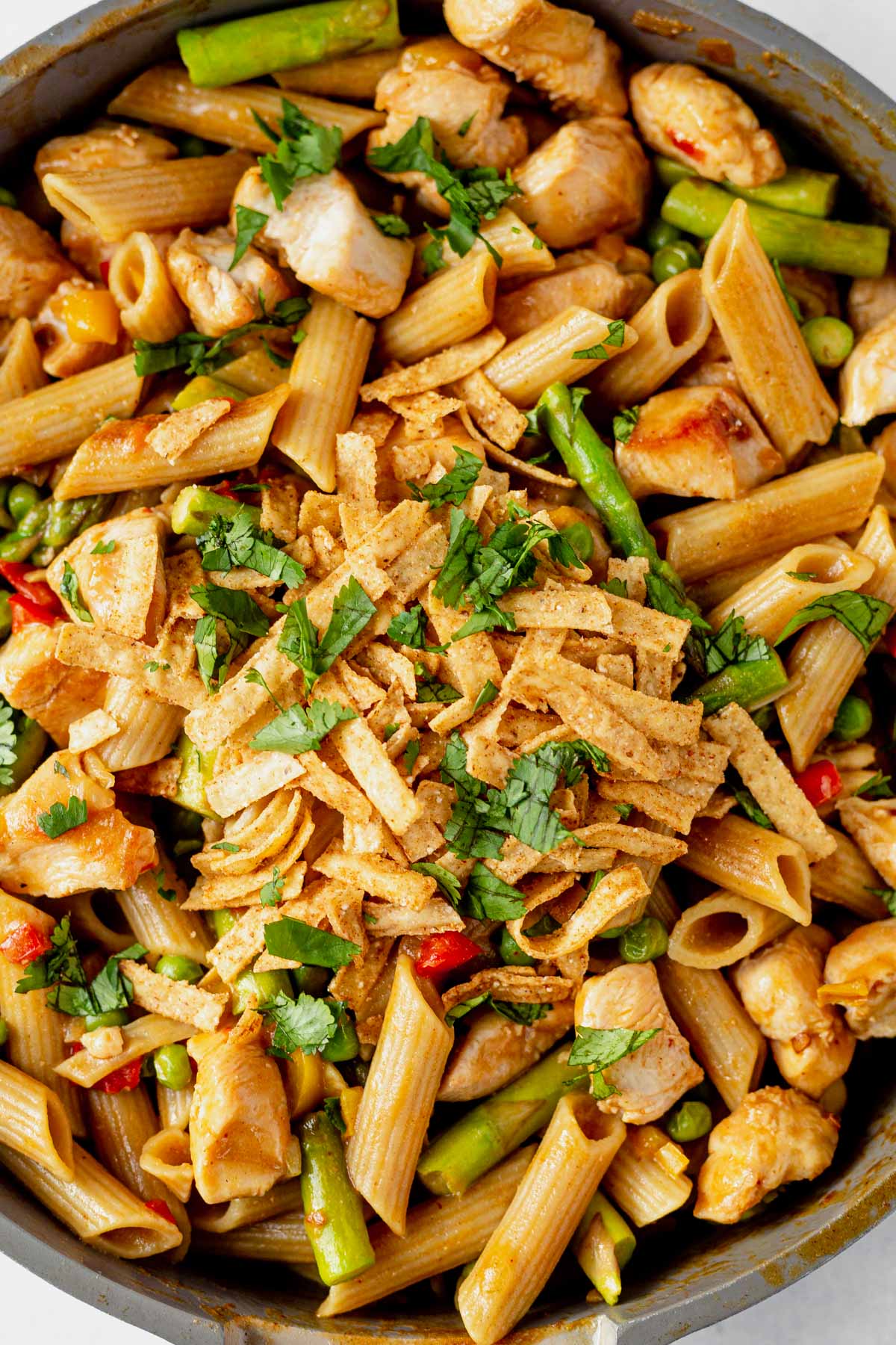 a pot of copycat cheesecake factory spicy chicken chipotle pasta with fresh cilantro
