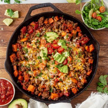 beef taco skillet with melted cheese, avocado and cilantro on top
