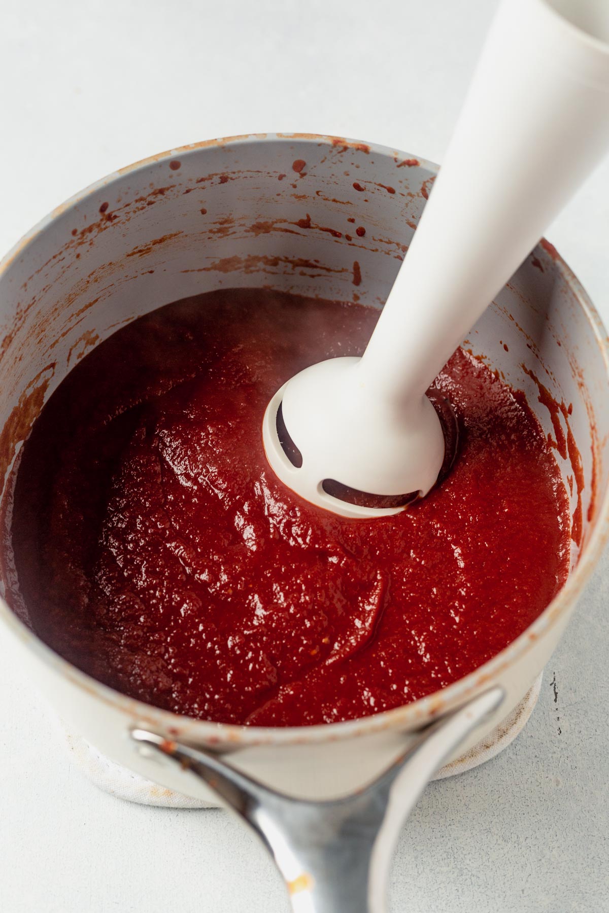 an immersion blender mixing whole30 bbq sauce until smooth