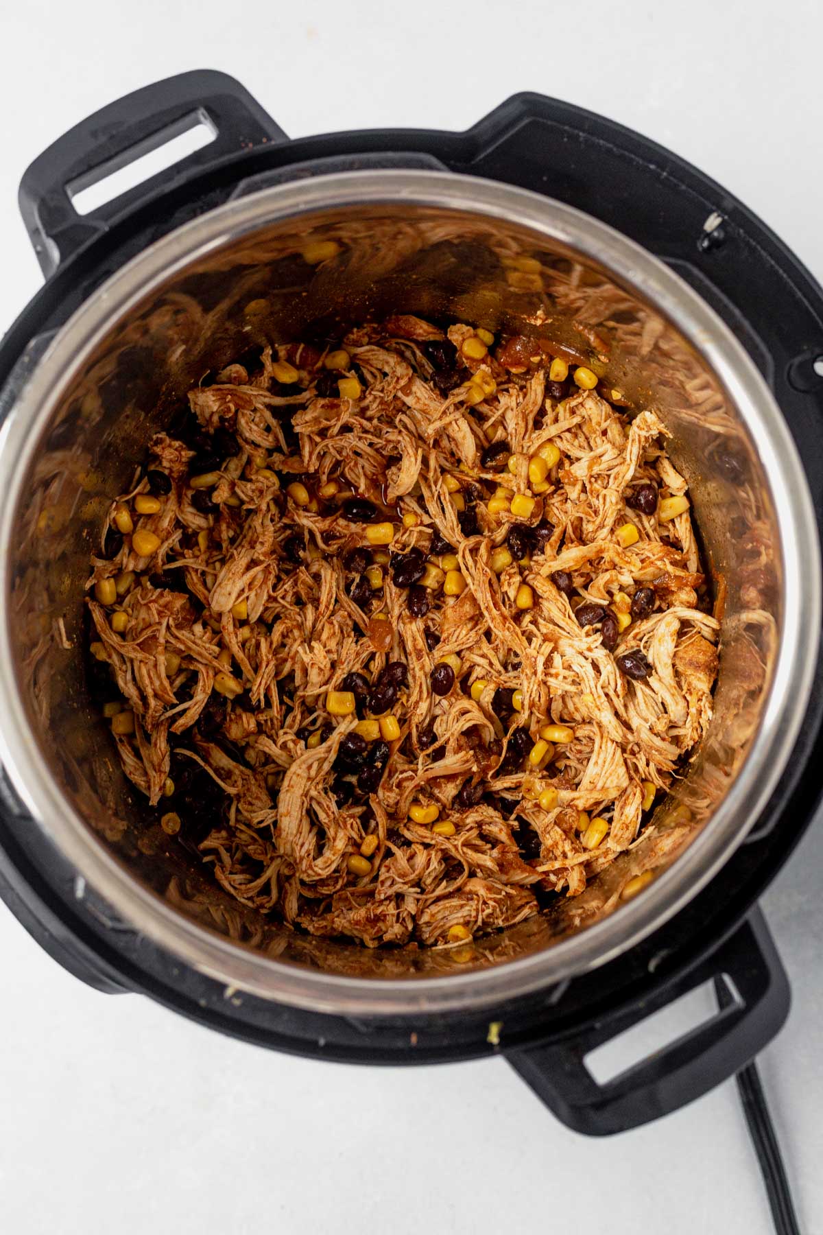 Shredded chicken, corn and black beans in the Instant Pot with enchilada sauce
