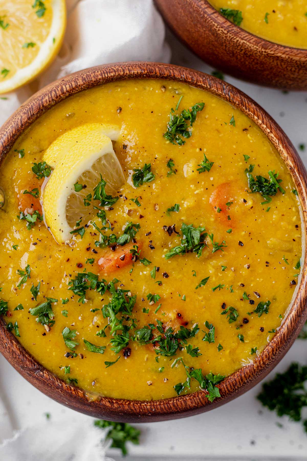 lemon lentil soup in a wood bowl with fresh parsley