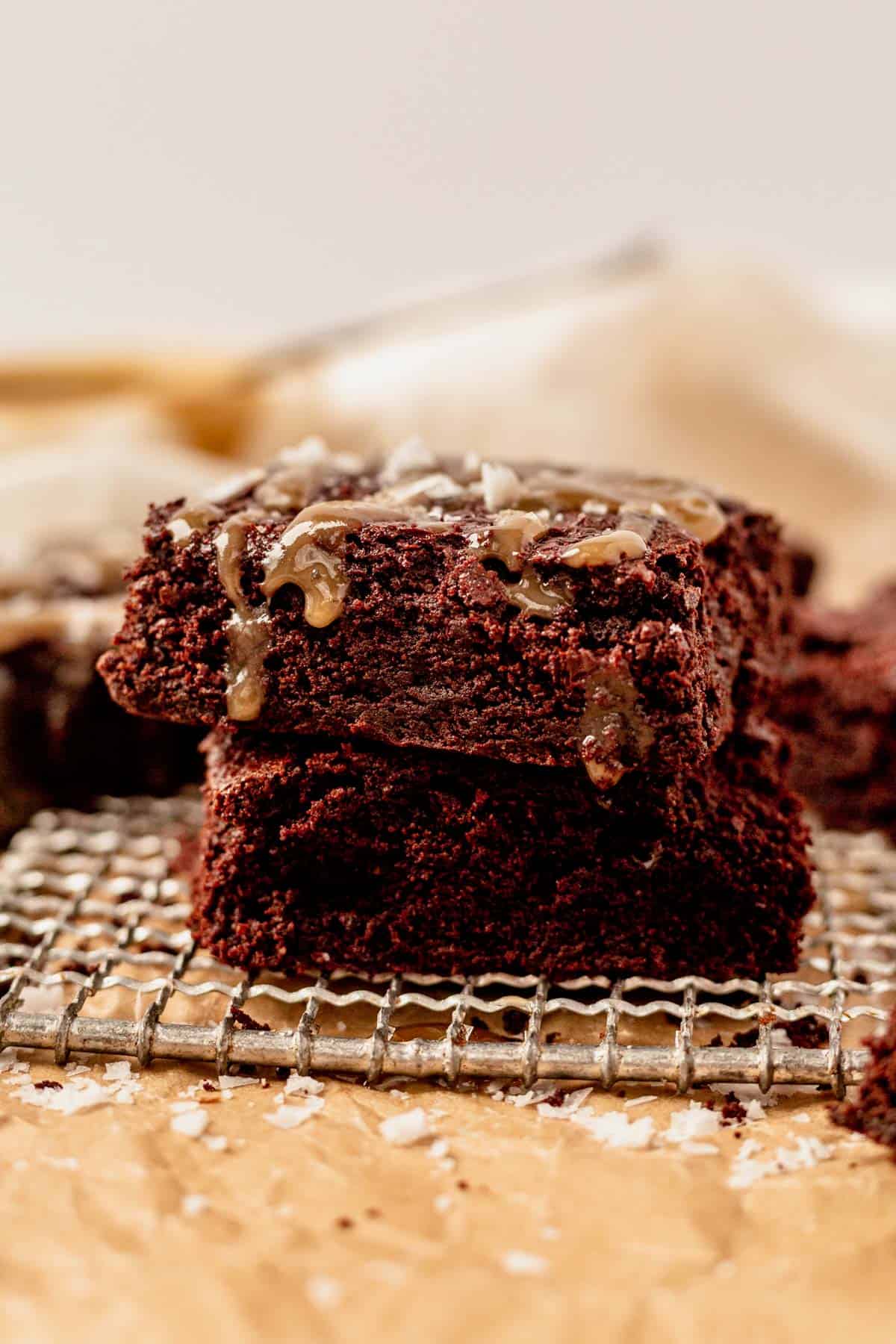 two tahini brownies stacked on parchment paper