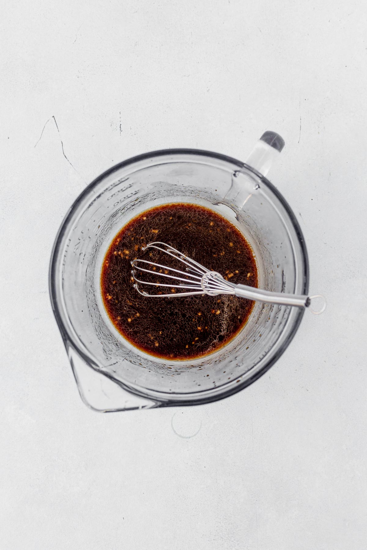 teriyaki sauce in a measuring bowl with a whisk