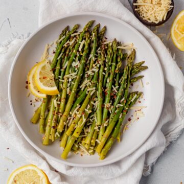 Instant Pot asparagus on a platter with fresh lemon slices and parmesan cheese