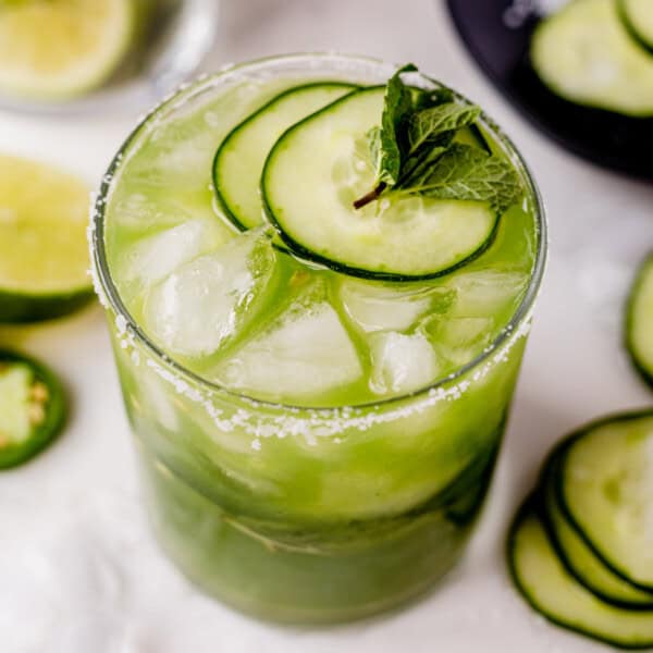 fresh cucumber margarita with cucumber slices on a countertop