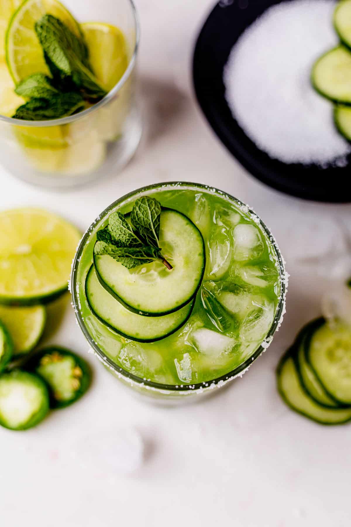 the top of a cucumber margarita filled with ice and topped with cucumber slices