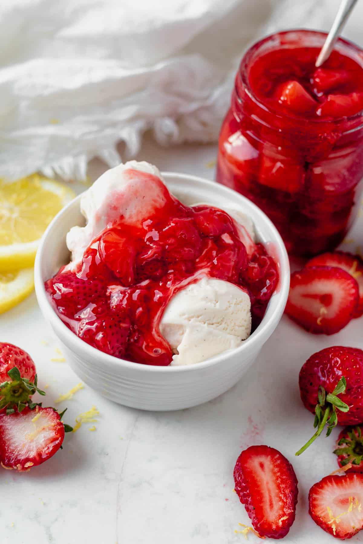 strawberry compote on top of a bowl of vanilla ice cream