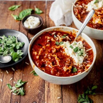 instant pot lasagna soup in a bowl with fresh oregano and ricotta