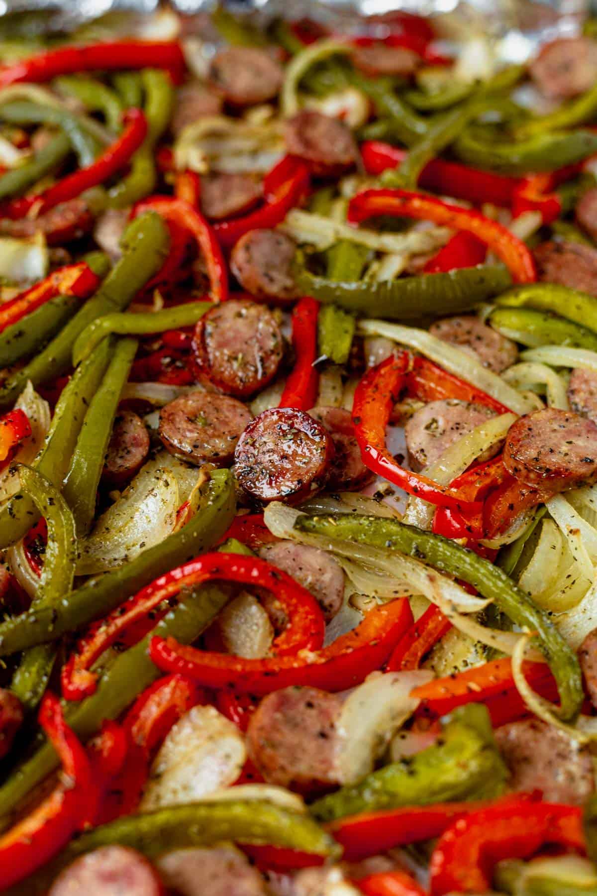 red and green bell peppers roasted with Italian sausage in the oven