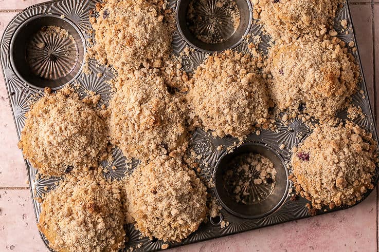 baked blueberry crumb muffins in a muffin tin