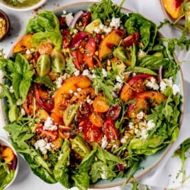 grilled peach salad in a large serving bowl