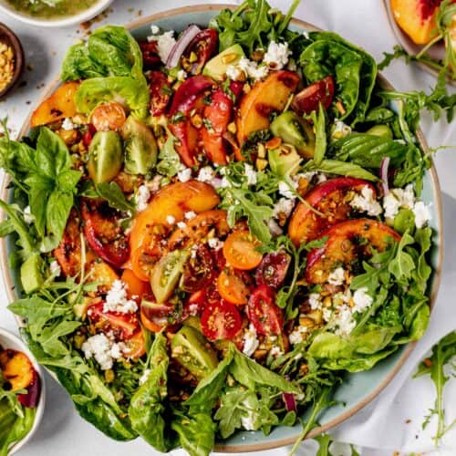 grilled peach salad in a large serving bowl