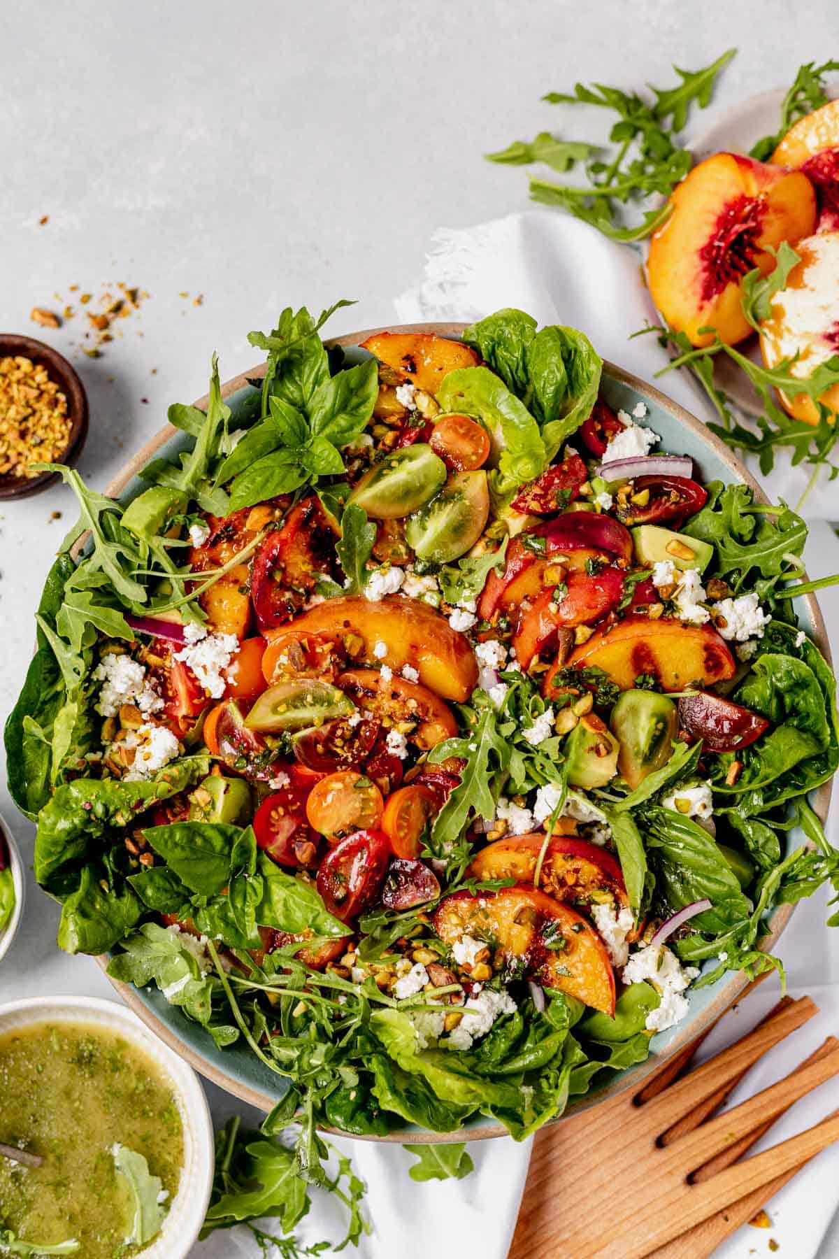 grilled peach salad in a bowl with salad forks