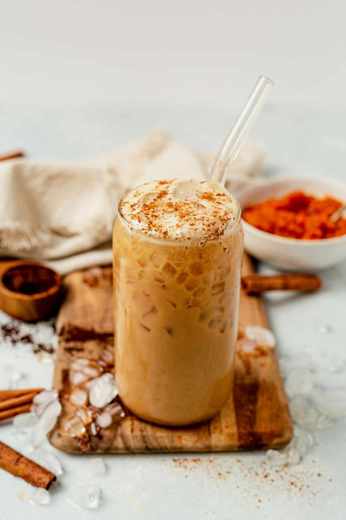 iced pumpkin spice latte with foam and cinnamon on top