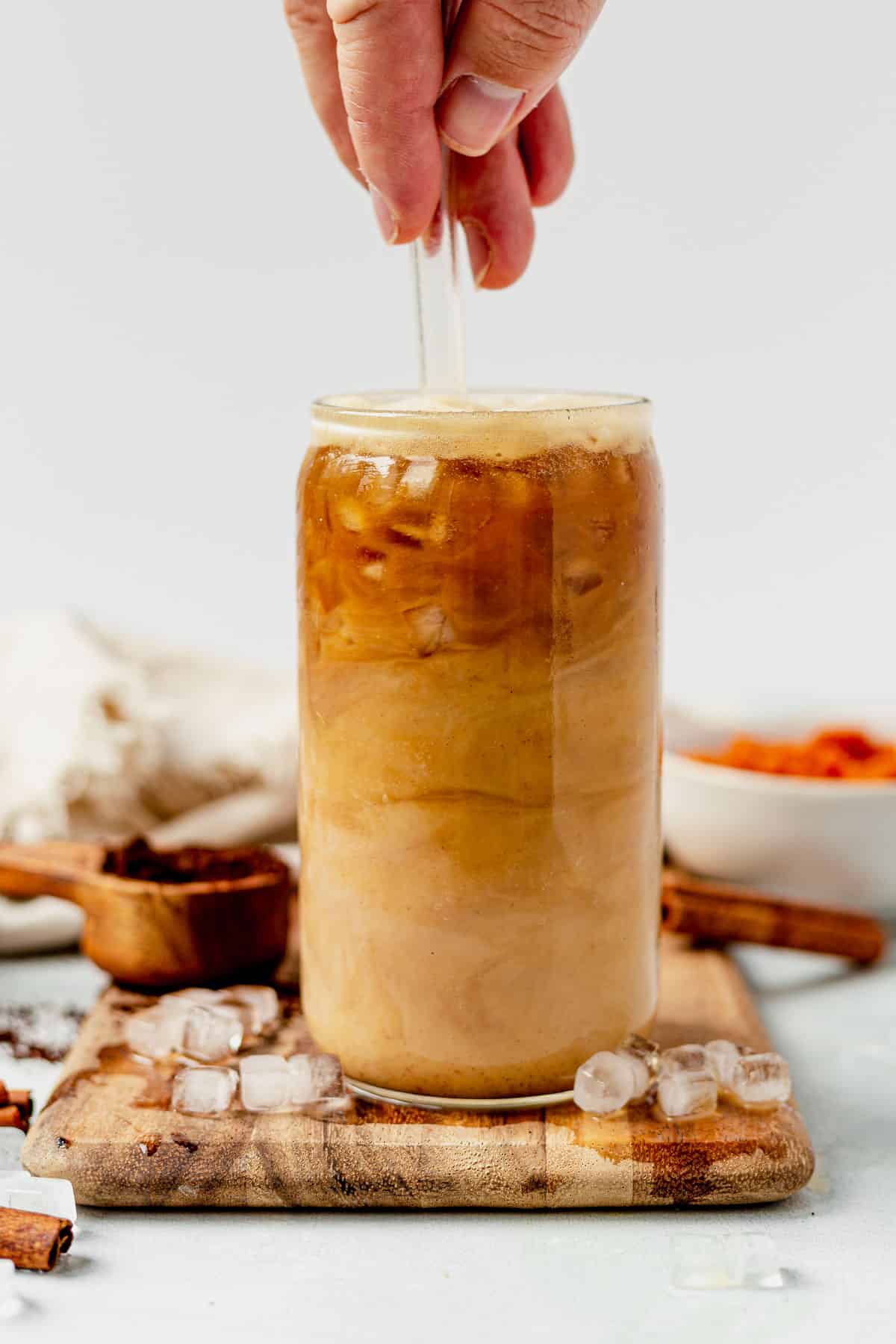 stirring an iced pumpkin spice latte