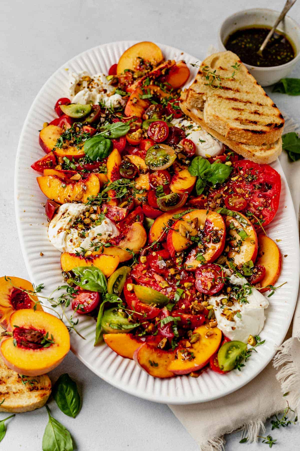 peach burrata salad on a large white platter