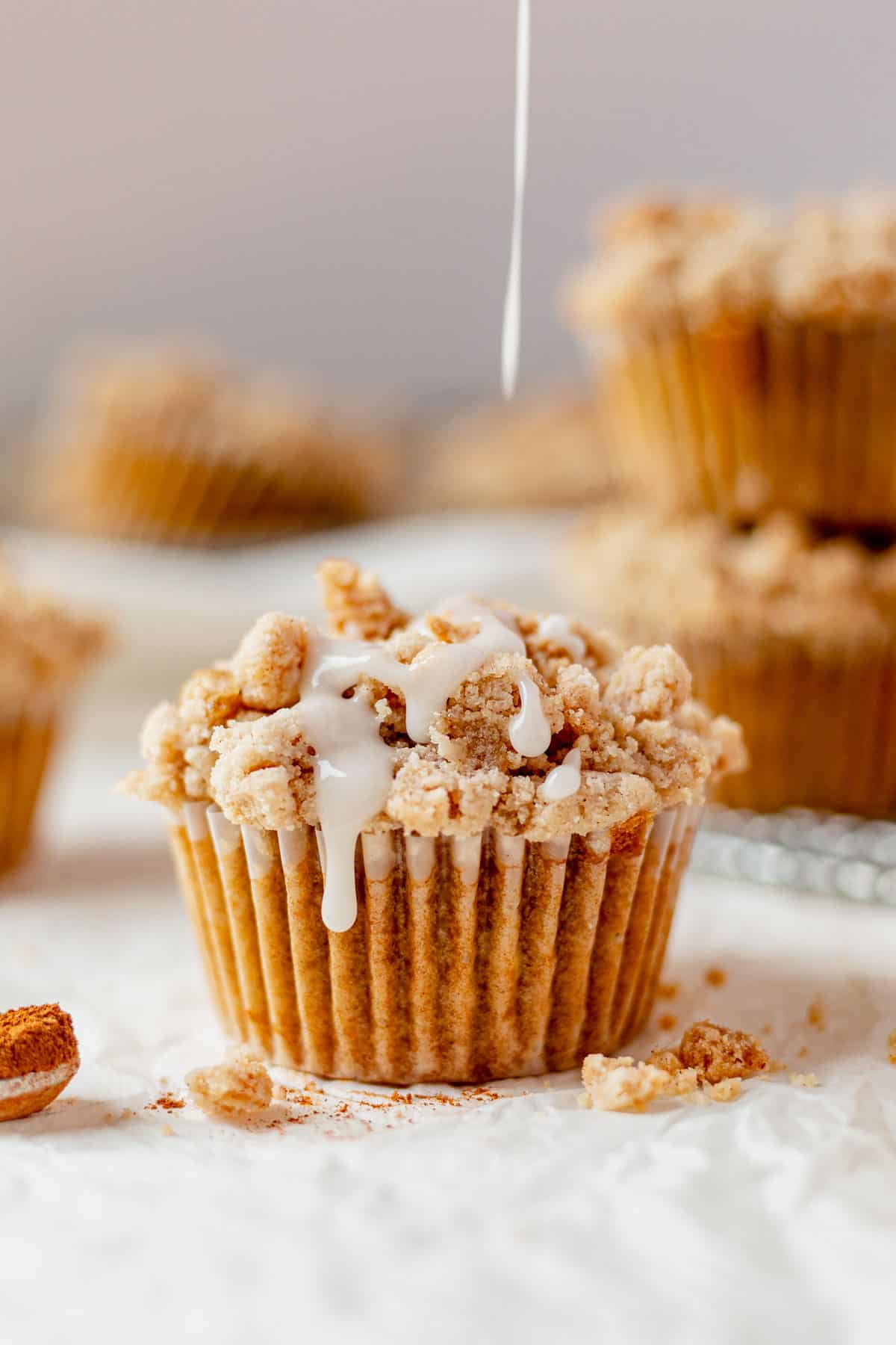 coffee cake muffin on parchment paper with icing drizzled on top
