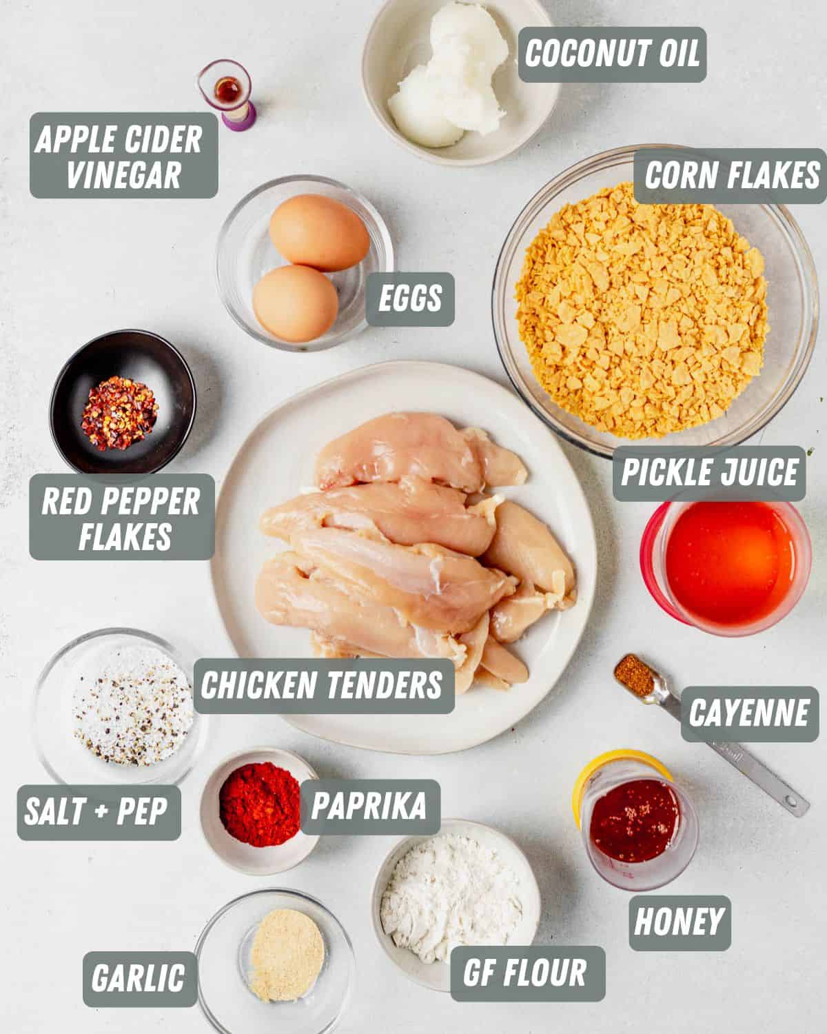 chicken tenders, spices, eggs, cornflakes and flour measured out on a table
