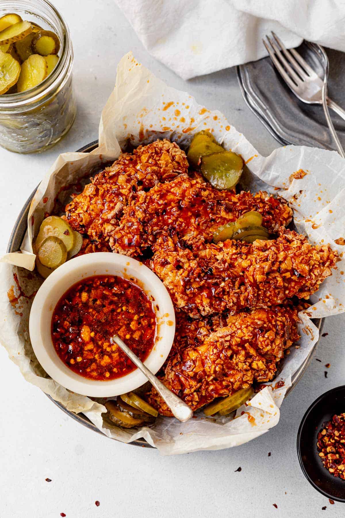 hot honey chicken tenders in a basket with pickles