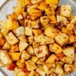 diced peaches and apples in a glass bowl with sugar, flour and cinnamon