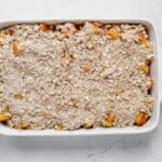 diced peaches and apples in a baking dish with crisp topping