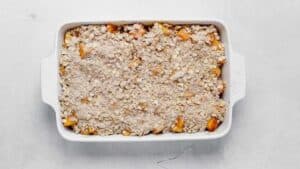 diced peaches and apples in a baking dish with crisp topping