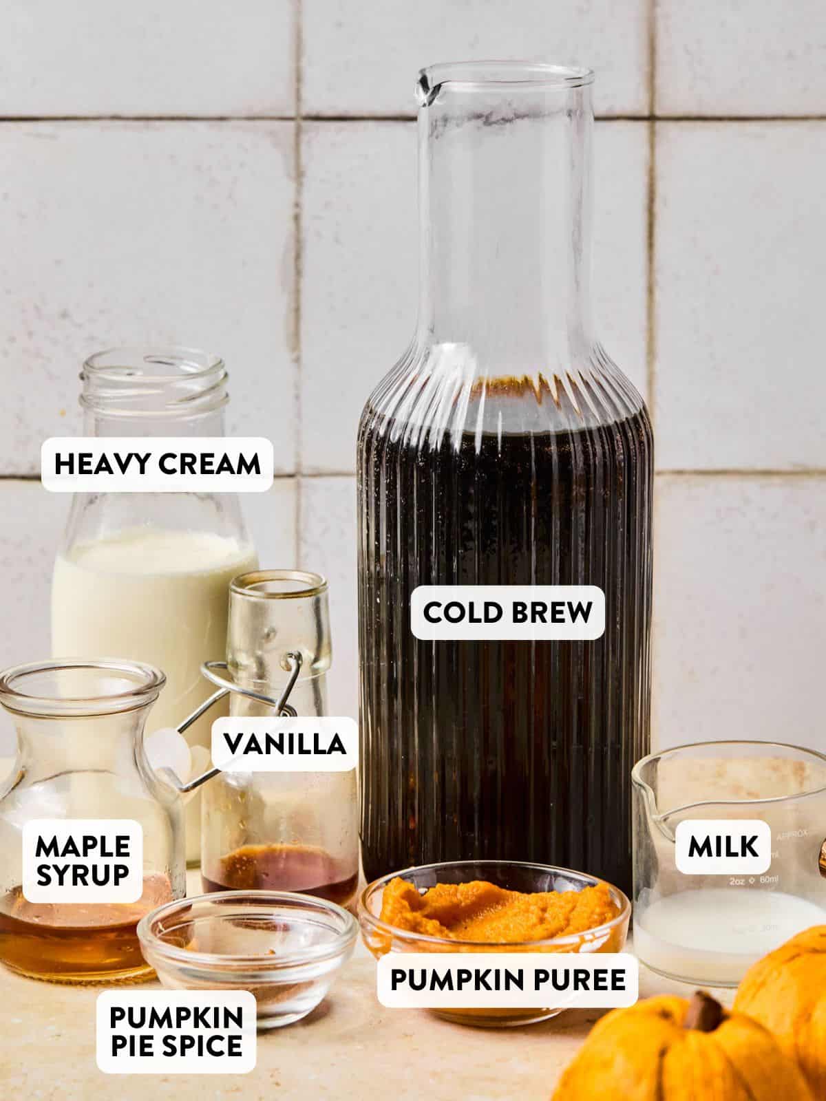 cold brew, heavy cream, pumpkin puree, pumpkin pie spice, syrup, and milk on a counter for homemade pumpkin cream cold brew.