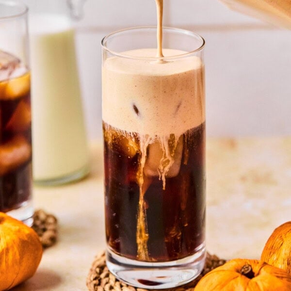 a glass of pumpkin cream cold brew on a coaster.