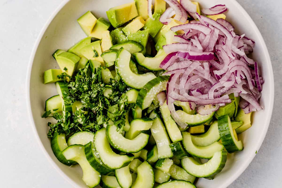 cucumber, onion, avocado, and cilantro in a bowl