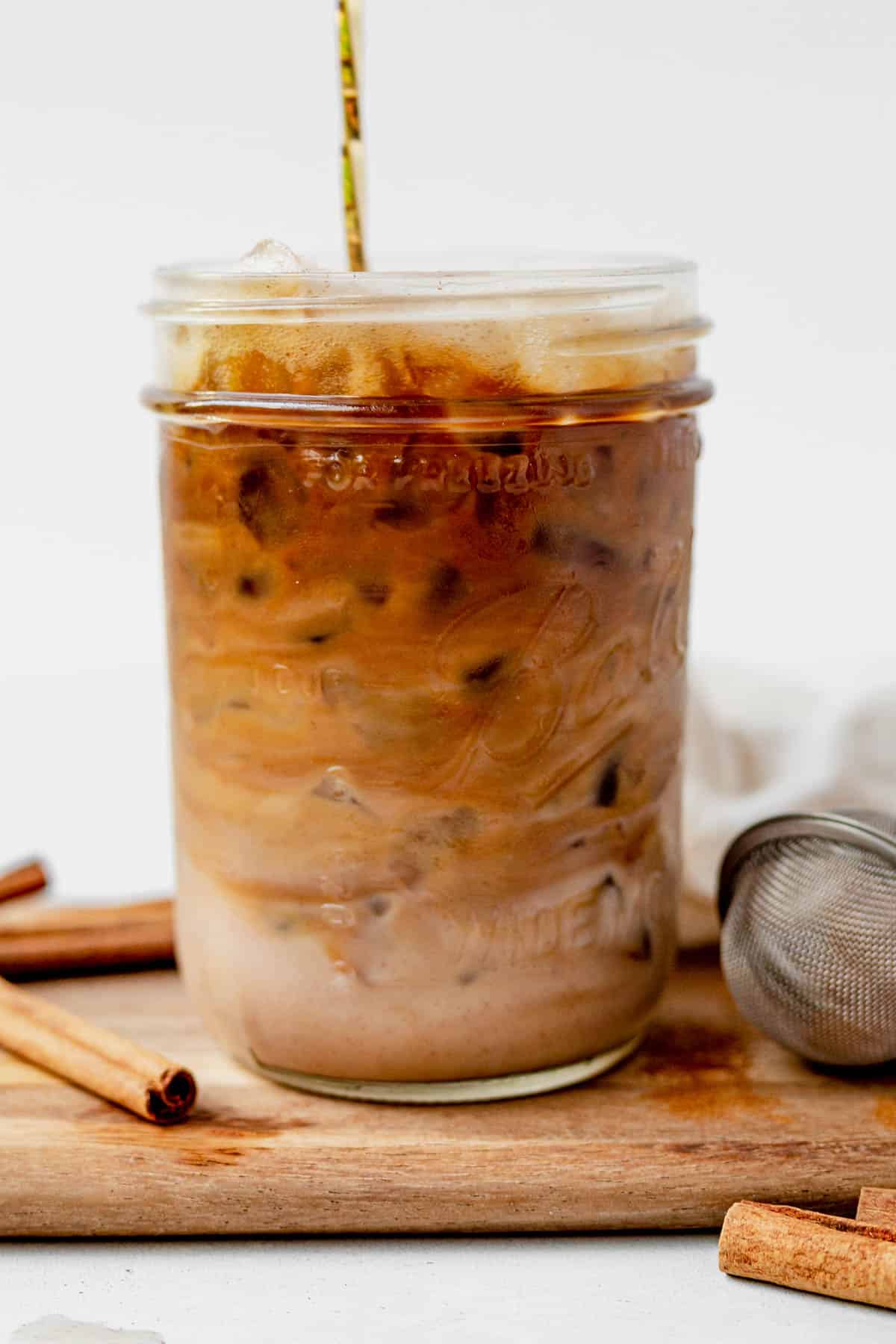 mixing a homemade starbucks iced cinnamon dolce latte in a mason jar