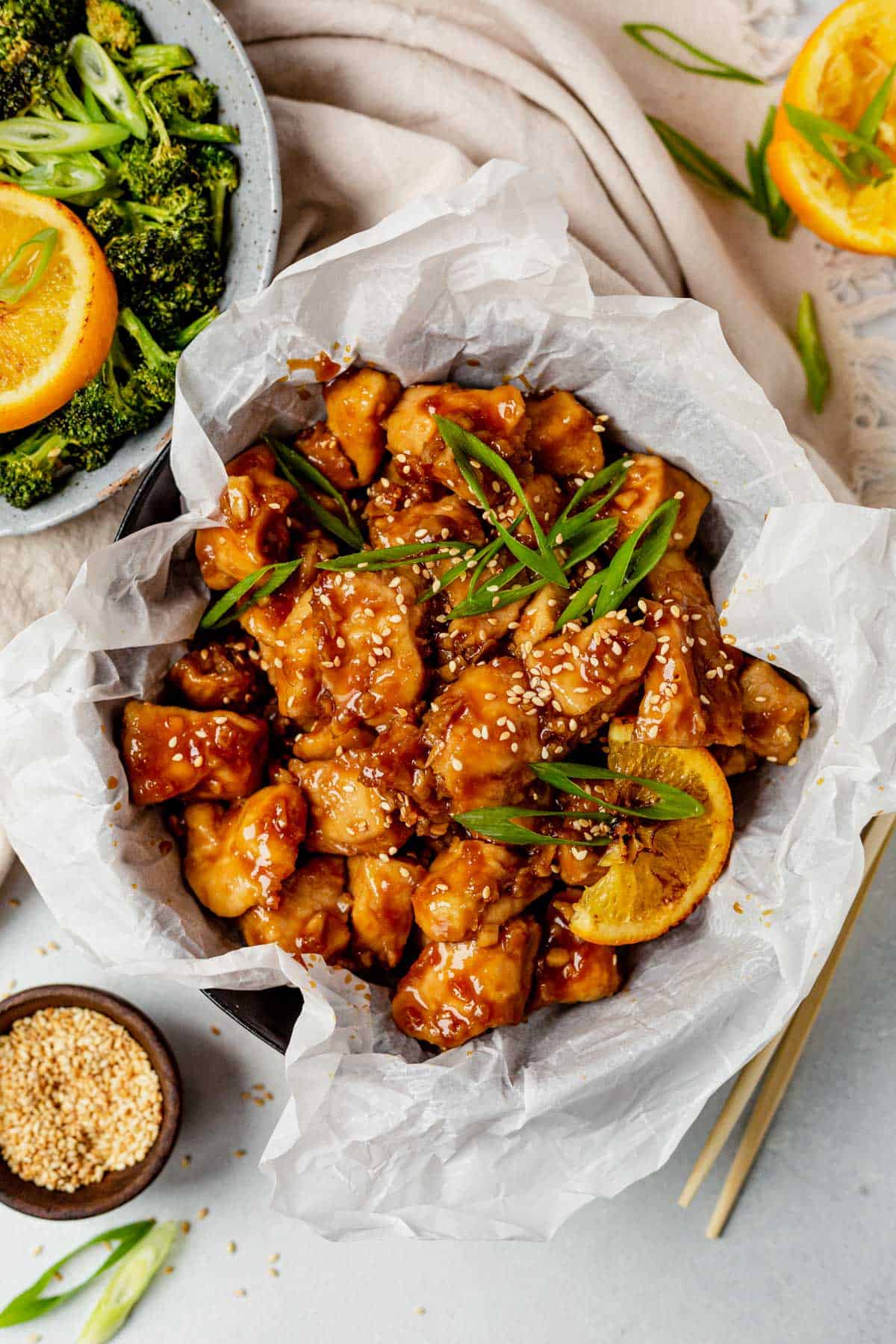 air fryer orange chicken in a serving dish with green onions