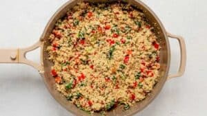 cooked quinoa, peppers and spinach in a pan