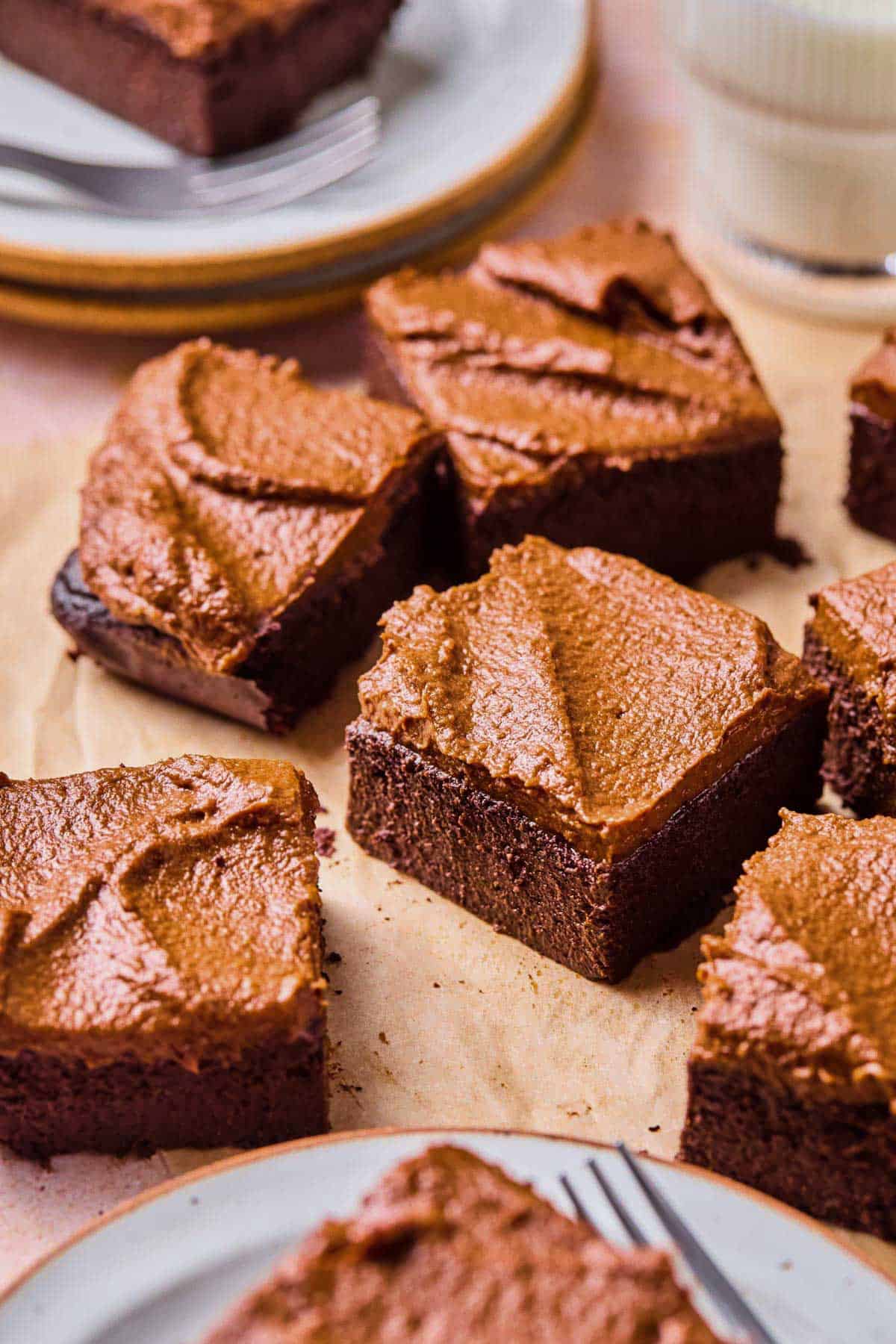 slices of chocolate potato cake on a piece of parchment paper with a glass of milk on the side.