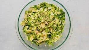 shredded brussels sprouts in a bowl with seasoning