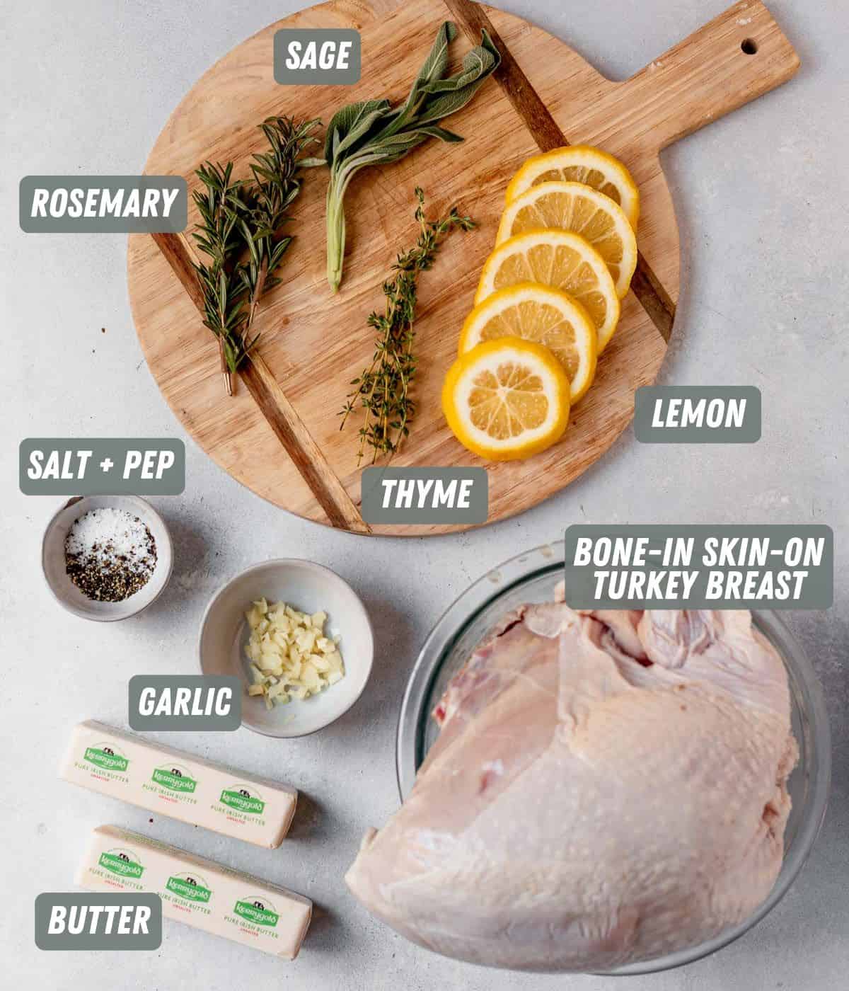 turkey breast, butter, lemon, garlic and herbs on a cutting board