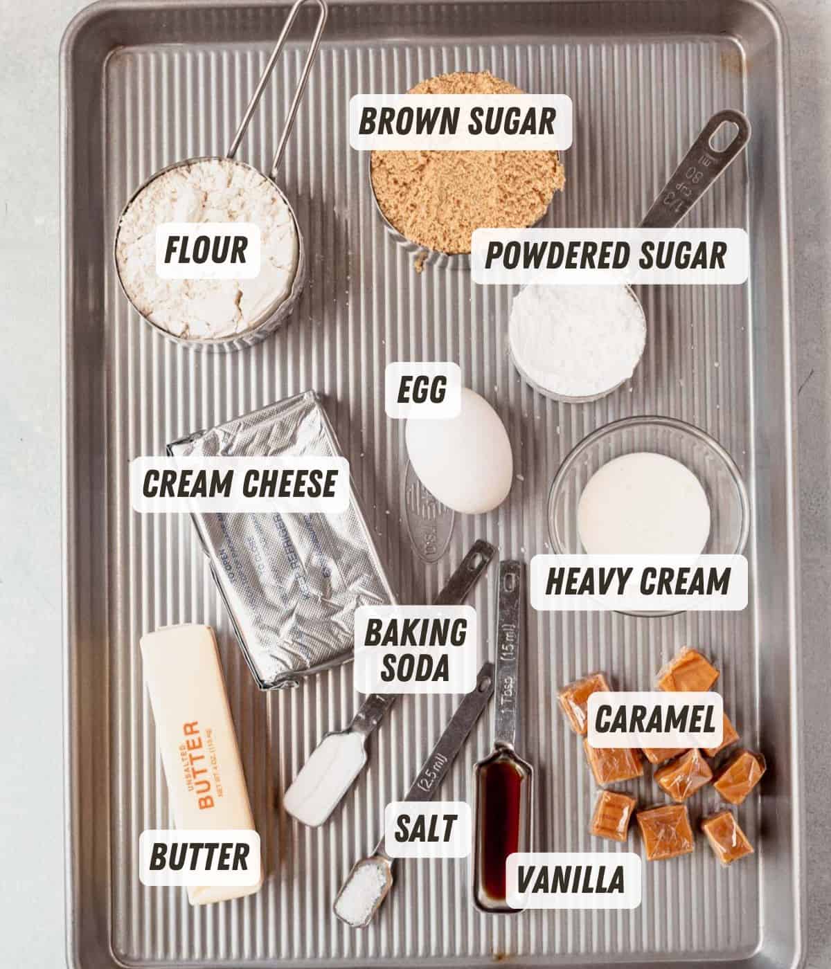 flour, cream cheese, brown sugar, butter, egg, baking soda, and caramels on a sheet pan