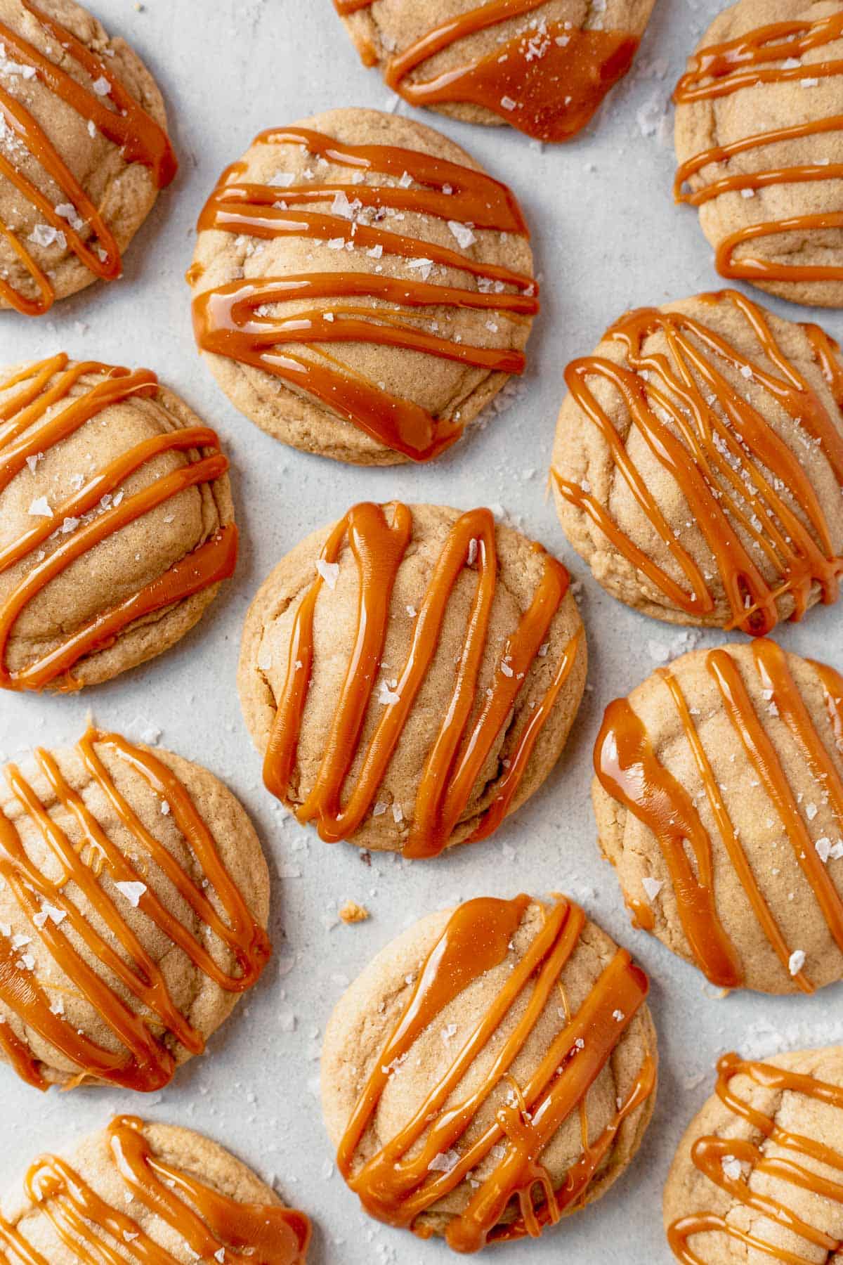 cheesecake cookies with caramel topping cooling on parchment paper